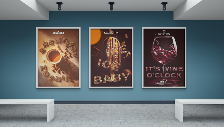 Three posters of iconic brands hanging on a blue wall in a gallery. On the left the logo of Lavazza, a cup of coffee seenfrom above and text made from coffee beans saying Brewtiful Morning. On the middle one the logo of Magnum Ice Cream, a chocolade ice on a stick with melted caramel running down on it and text made from chocolade and melted caramel saying Ice Ice Baby. On the right one the logo of Bodega Norton Winery, a glass of wine and text with wine effect saying It's Wine O'clock.