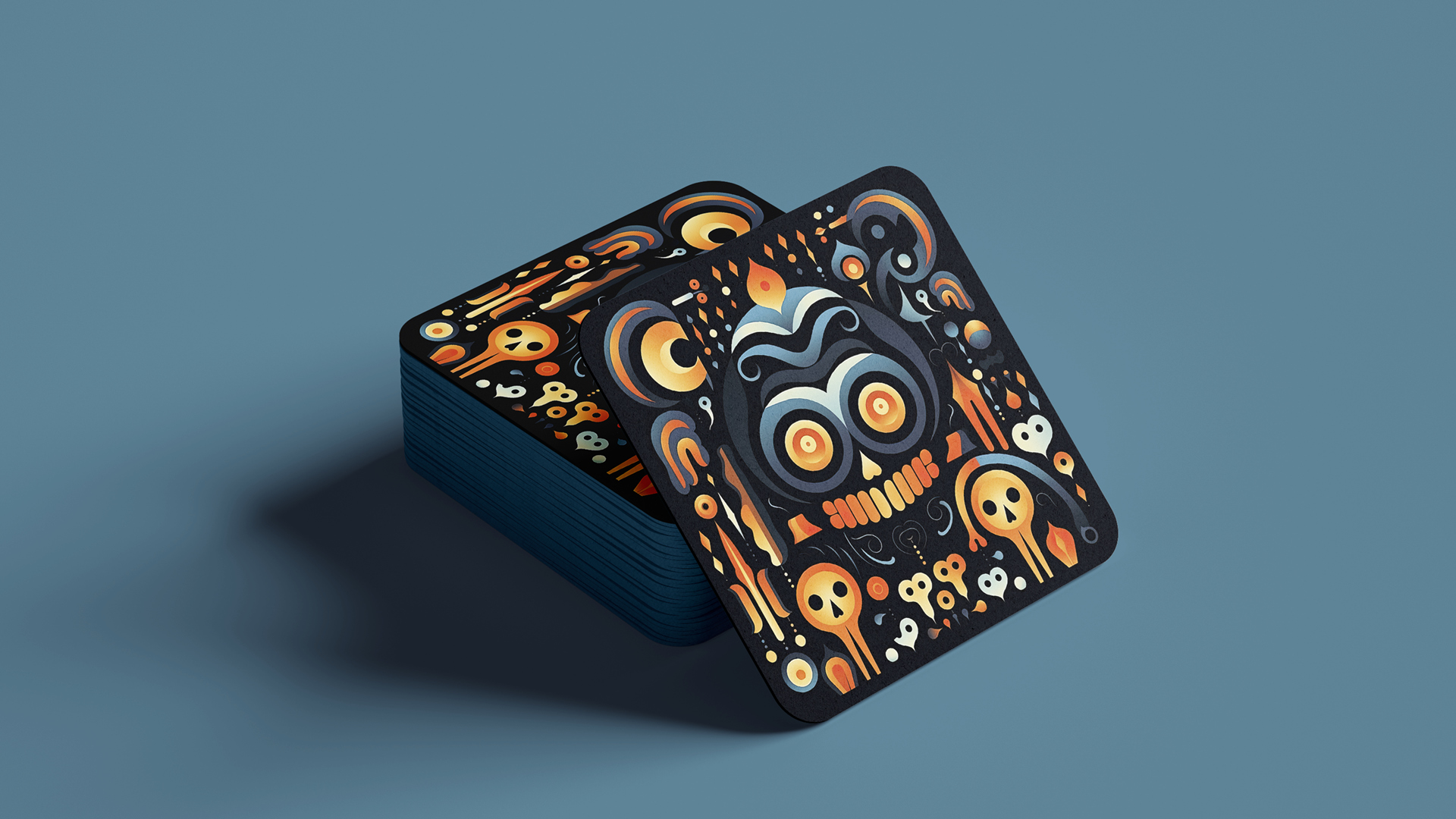 A stack of square coasters against a muted blue background. The top card showcases an intricate and colorful design dominated by a prominent stylized skull with swirling eyes in the center. Surrounding the skull are various Halloween-themed elements such as smaller skulls, ghostly figures, candles, and abstract swirls and patterns. The color palette consists of deep oranges, blacks, whites, and touches of blues.