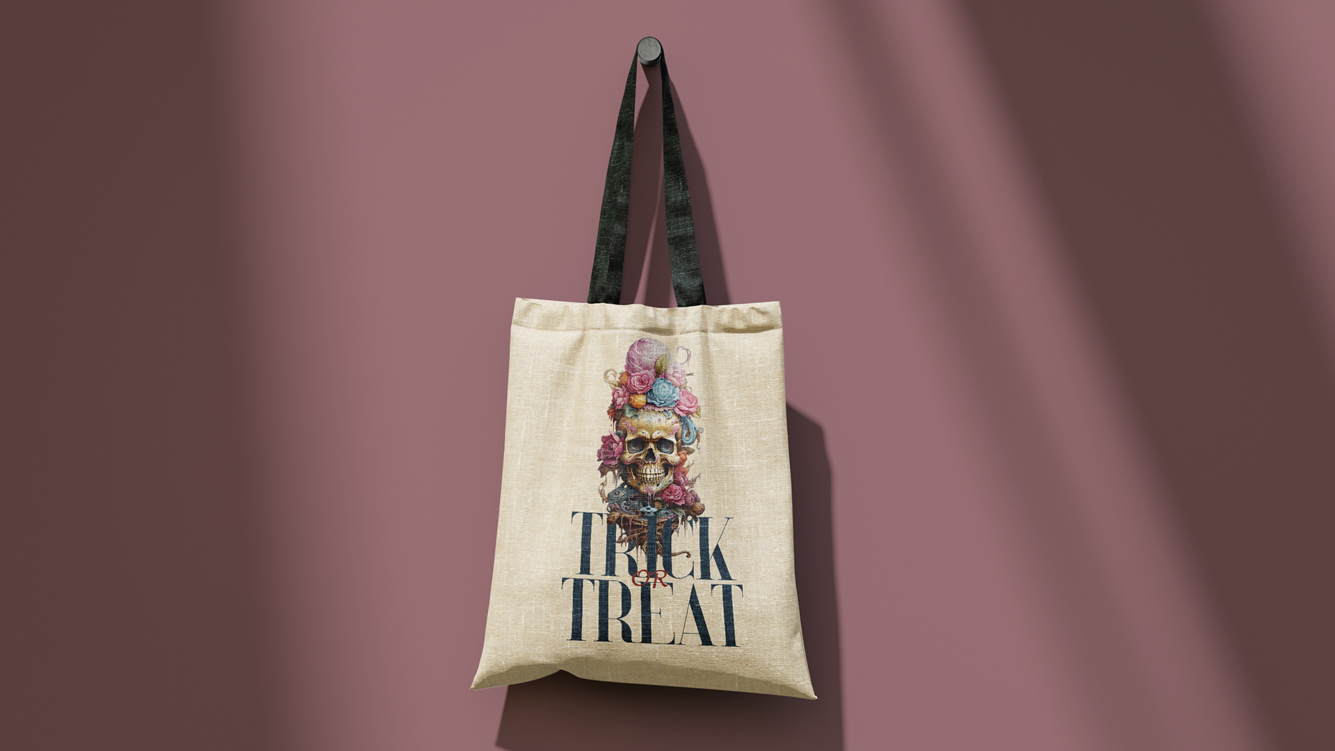 A beige tote bag with black handles hanging against a gradient purple background. The bag features a detailed illustration of a skull adorned with colorful flowers and the words 'TRICK OR TREAT' printed below.